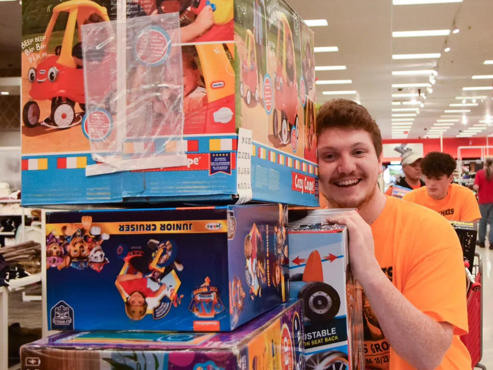 man at Target with a cart full of toys to be donated to kids in need