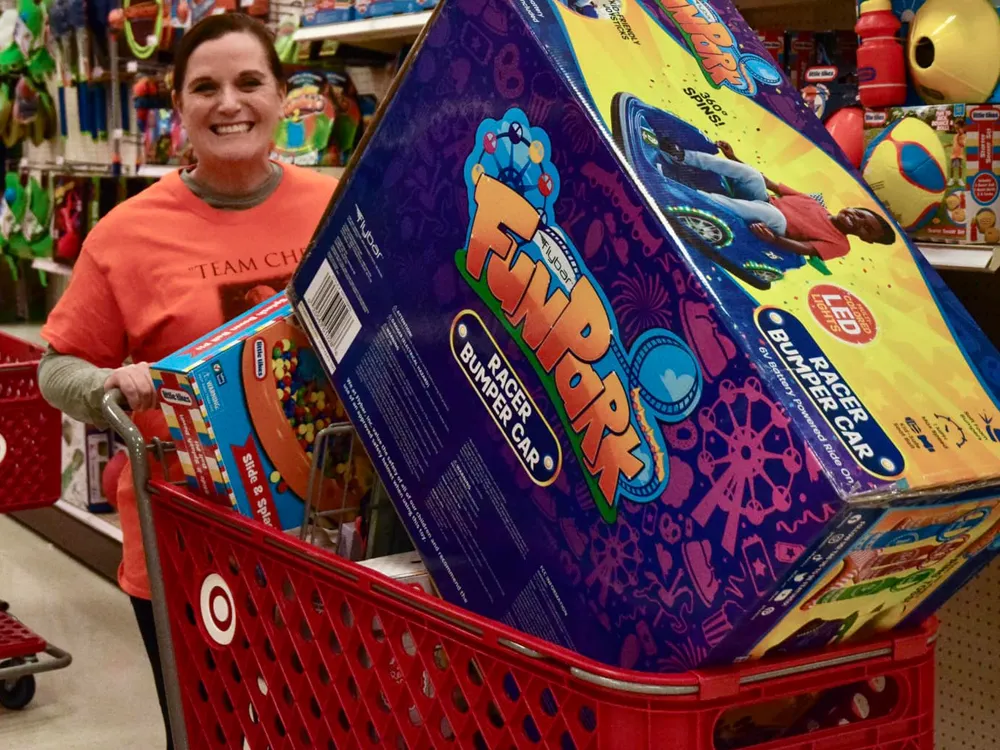 woman at Target with a cart full of toys to be donated to kids in need